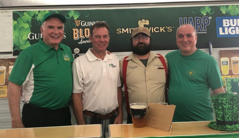 Rep. Mike Kelly, state Senator Dan Laughlin, William Sabatini, and Randy Bristello stand behind the bar at the Saint Patrickâs Irish Festival in the city of Erie, Penn.