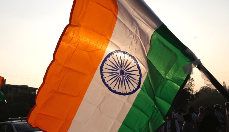 People carry Indian flags as they walk to join others to form a human chain to mark the death anniversary of India's independence leader Mahatma Gandhi and to protest against a new citizenship law that opponents say threatens India's secular identity in Bangalore, India, Thursday, Jan. 30, 2020. The new citizenship law and a proposed National Register of Citizens have brought thousands of protesters out in the streets in many cities and towns since Parliament approved the measure on Dec. 11.