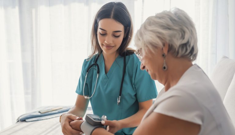 A nurse measuring the blood pressure of an elderly woman.