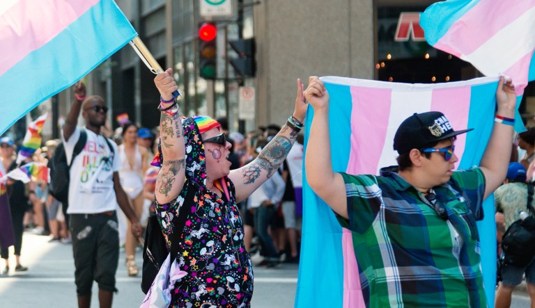 Participants walk at the annual LGBTQ Pride parade in Montreal on Rene-Levesque Boulevard, including people with transgender community flags.