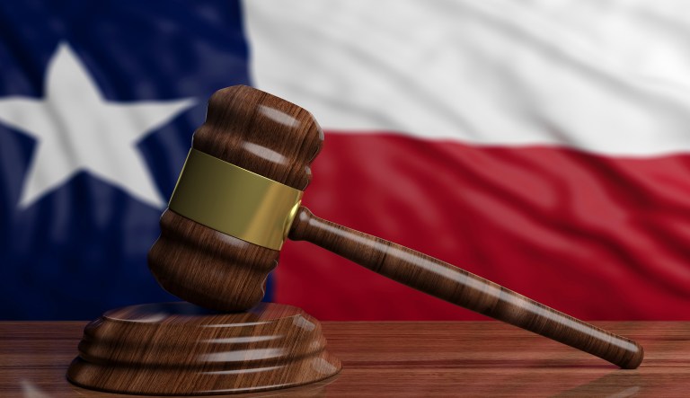 Judge gavel on Texas flag background.