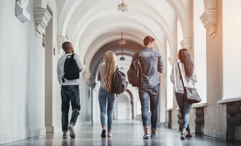 Students walking in a university hall during break.