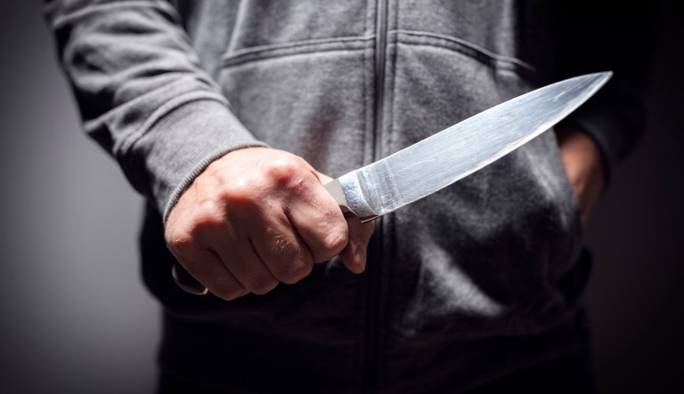Criminal with knife weapon threatening to stab