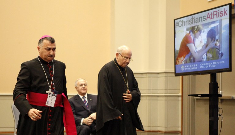Archbishop Bashar Matti Warda, of Erbil, Iraq, left, and Archbishop Jean-Clement Jeanbart, of Aleppo, Syria, speak at a news conference on the plight of persecuted Middle Eastern Christians, at a news conference where the Knights of Columbus announced a fundraising and advertising campaign to raise awareness of oppression in the Middle East, Tuesday, Aug. 4, 2015, in Philadelphia. The Syrian archbishop appealed to the American people Tuesday for help withstanding Islamic militants fighting to root out their faith.