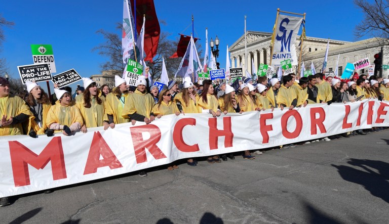 Caroline McCarthy, right to left, Stephanie Keiser, and Brian White all from Wexford, Penn., join thousands of pro-life protestors as they march towards the U.S. Supreme Court, marking the 32nd anniversary of the Supreme Court decision legalizing abortion, Monday, Jan. 24, 2005, in Washington.