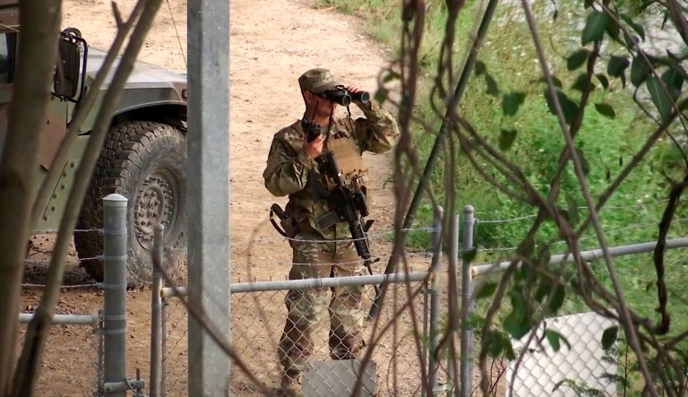 FILE - In this April 10, 2018, file frame from video, a National Guard troop watches over Rio Grande River on the border in Roma, Texas. President Donald Trump has asked governors to deploy thousands of National Guard troops to the border with Mexico, citing a recent surge in people crossing illegally. Apprehensions at the border fell sharply shortly after Trump took office last year but they have gradually increased in recent months. Texas Gov. Greg Abbott, who is running for re-election this year, has eagerly complied with Trump's request, dispatching hundreds of guard members and saying that the Texas contribution could reach 1,400 or more.
