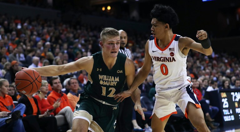 Zack Wajsgras/AP
William and Mary's guard Luke Loewe (12) drives around Virginia's guard Kihei Clark (0) in the first half at John Paul Jones Arena on Saturday. Virginia went into the half with a 34-23 lead.               