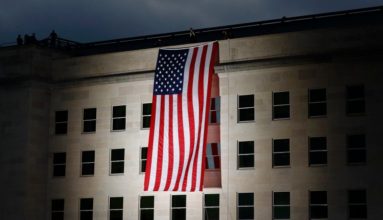 An American flag is unfurled at sunrise at the Pentagon in Washington on the 18th anniversary of the September 11th attacks, Wednesday, Sept. 11, 2019.