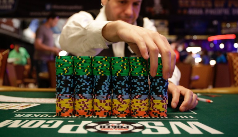 FILE - In this July 5, 2014, file photo, dealer Omar Abu-Eid adjusts a stack of chips before the first day of the World Series of Poker main event at at the Rio All-Suite Hotel & Casino in Las Vegas. Caesars Entertainment Corp. is selling the Rio All-Suite Hotel & Casino to an Imperial affiliate for $516.3 million. 