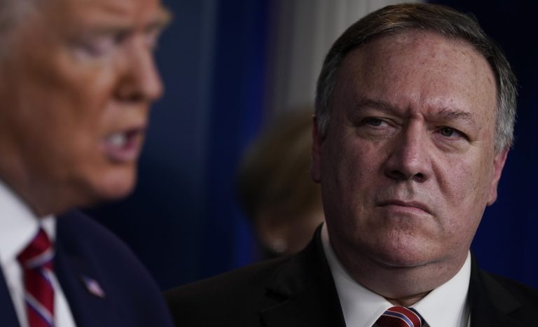Secretary of State Mike Pompeo, right, listens as President Donald Trump speaks during a coronavirus task force briefing at the White House, Friday, March 20, 2020, in Washington.