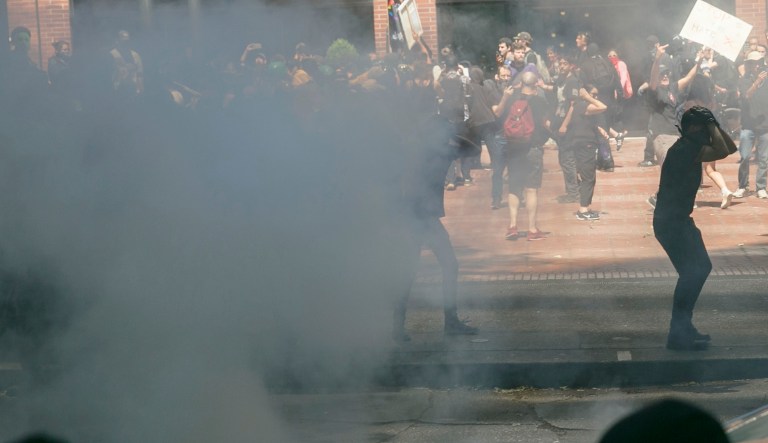 Police push protesters back with tear gas and flash-bang grenades during a rally in Portland, Ore., Saturday, Aug. 4, 2018. Small scuffles broke out Saturday as police in Portland, Oregon, deployed "flash bang" devices and other means to disperse hundreds of right-wing and self-described anti-fascist protesters.