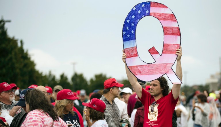 David Reinert holding a Q sign waits in line with others to enter a campaign rally with President Donald Trump Republican U.S. Senate candidate Rep. Lou Barletta, R-Pa., Thursday, August 2, 2018 in Wilkes-Barre, Pa.