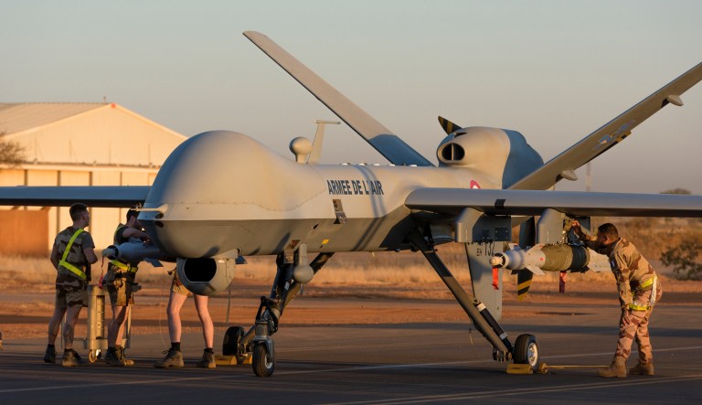 This photo provided by the French Defense Ministry communication center and taken Tuesday Dec. 17, 2019, shows French soldiers loading a French Reaper drone with two GBU 12 missiles on Niamey airbase, Niger. France's defense ministry said Monday that it had carried out its first armed drone strike, killing seven Islamic extremists in central Mali over the weekend. France joins a tiny group of countries that use armed drones, including the United States.