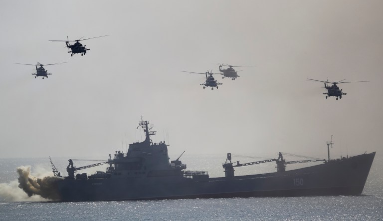 A Russian navy ship and helicopters take a part in a landing operation during military drills at the Black Sea coast, Crimea, Friday, Sept. 9, 2016. 