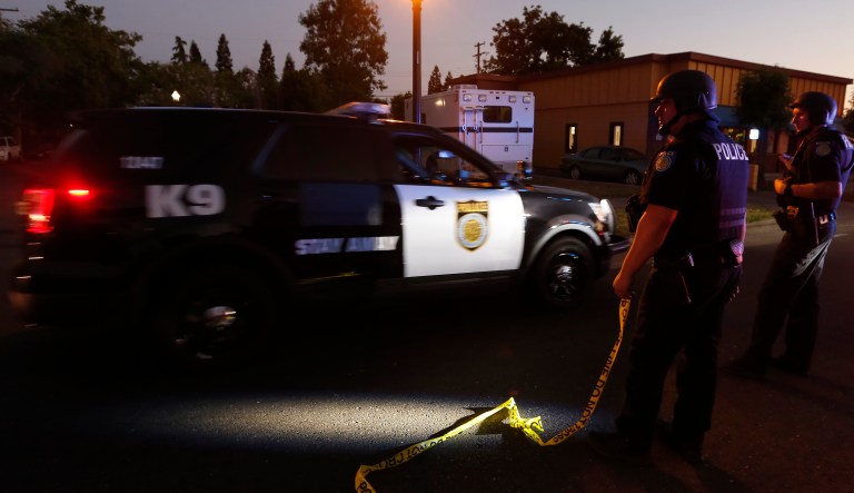 A Sacramento Police vehicle passes a roadblock near a home that authorities have surrounded where an armed suspect has taken refuge after shooting a Sacramento police officer, Wednesday, June 19, 2019, in Sacramento, Calif. 