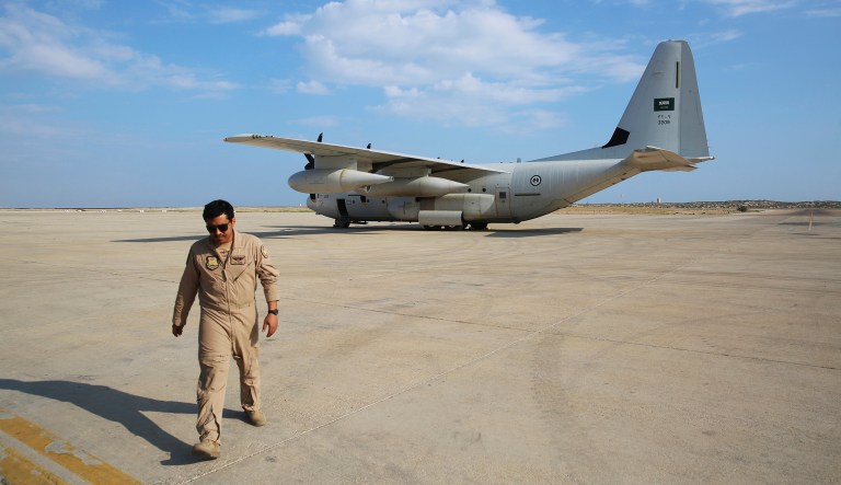 In this Wednesday, Nov. 28, 2018, photograph, an airman with the Royal Saudi Air Force walks away from a C-130 Hercules military cargo plane near Mukalla, Yemen, at an airport now serving as a military base for the United Arab Emirates. The port city of Mukalla, once held by al-Qaida, shows how fractious Yemen is and will remain even if the Saudi-led war in the country ends in an uneasy peace for the Arab world's poorest nation.