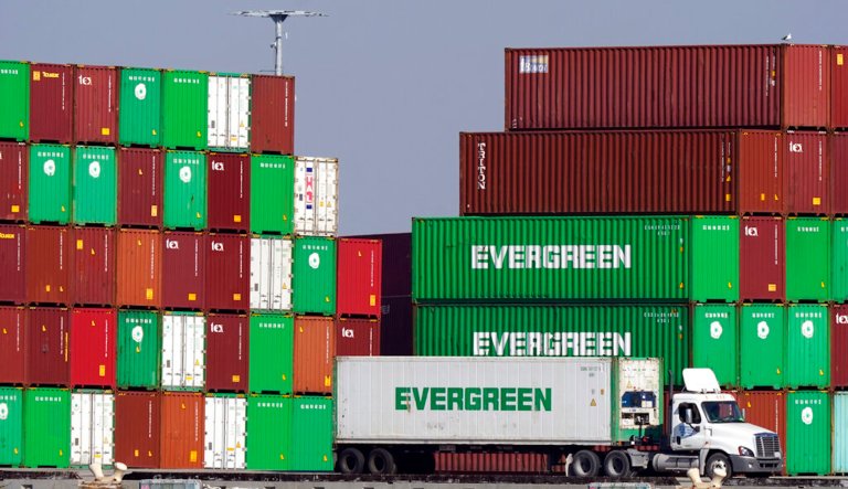 Shipping containers are stacked over a truck at the Port of Los Angeles Wednesday, Nov. 10, 2021, in Los Angeles. One month after President Joe Biden announced an agreement to have the Port of Los Angeles operate round-the-clock to help break a cargo backlog at the docks, officials disclose that hasnât happened as they contend with a shortage of truck drivers and accessible warehouse space.  