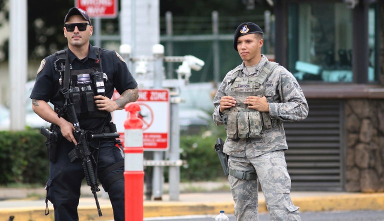 Security stand outside the main gate at Joint Base Pearl Harbor-Hickam Wednesday, Dec. 4, 2019, in Honolulu. A shooting at Pearl Harbor naval shipyard in Hawaii left at least one person injured Wednesday, military and hospital officials said. Joint Base Pearl Harbor-Hickam spokesman Charles Anthony confirmed that there was an active shooting at Pearl Harbor naval shipyard. The military tweeted that it began around 2:30 p.m. Queen's Medical Center spokesperson Cedric Yamanaka said the hospital was treating one patient but didn't give e details on their condition.