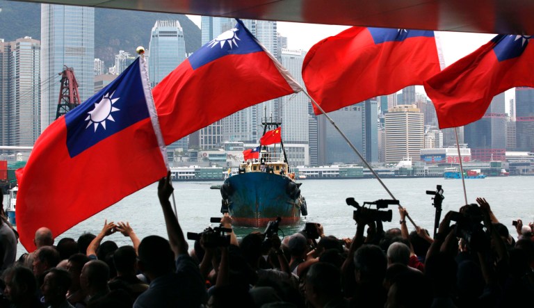 Supporters wave Taiwan flags as they welcome activists aboard the fishing boat "Kai Fung No. 2" in Hong Kong Wednesday, Aug. 22, 2012. A group Hong Kong activists deported from Japan after landing on disputed islands in the East China Sea returned home to a hero's welcome. The seven activists who returned Wednesday were part of a 14-person group that evaded the Japanese Coast Guard to reach the islands a week ago.
