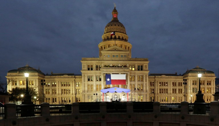 In this Jan. 14, 2019, photo, a large Texas flag hangs from the Texas State Capitol as workers prepare the grounds for inauguration ceremonies in Austin, Texas.