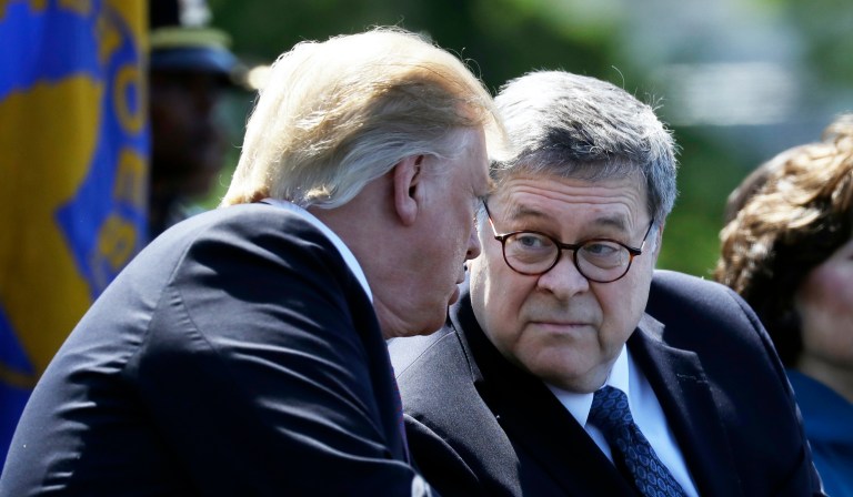 President Donald Trump moves from the podium to allow Attorney General William Barr to speak about the coronavirus in the James Brady Briefing Room, Monday, March 23, 2020, in Washington.