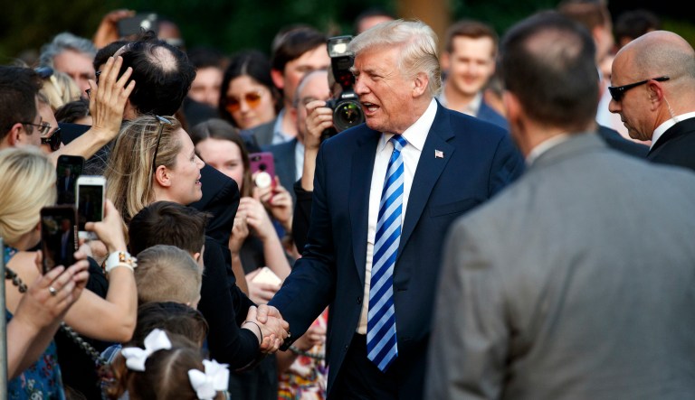 President Donald Trump greets people on the South Lawn of the White House in Washington, Friday, May 4, 2018, as he returns from Dallas.
