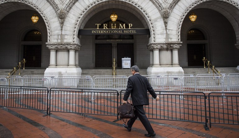 A pedestrian passes in front of the Trump International Hotel in Washington, D.C., U.S., on Tuesday, Jan. 17, 2017. U.S. President-elect Donald Trump plans to issue some executive orders on inauguration day and may swear in some of his cabinet members, according to Trump's spokesman Sean Spice. But the incoming president will wait until Monday, the first full business day of his presidency, for "a big flurry of activity."