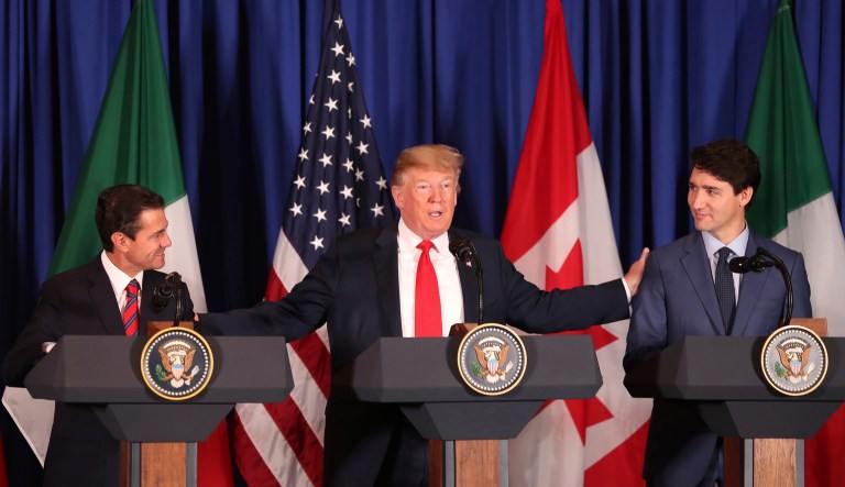 President Donald Trump, center, reaches out to Mexico's President Enrique Pena Nieto, left, and Canada's Prime Minister Justin Trudeau as they prepare to sign a new United States-Mexico-Canada Agreement that is replacing the NAFTA trade deal, during a ceremony at a hotel before the start of the G20 summit in Buenos Aires, Argentina, Friday, Nov. 30, 2018. The USMCA, as Trump refers to it, must still be approved by lawmakers in all three countries.