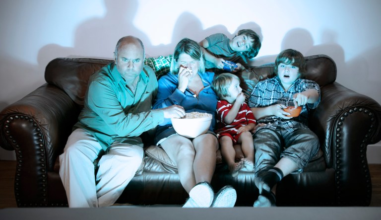 A comical photograph of a family enjoying movie night together at home.
