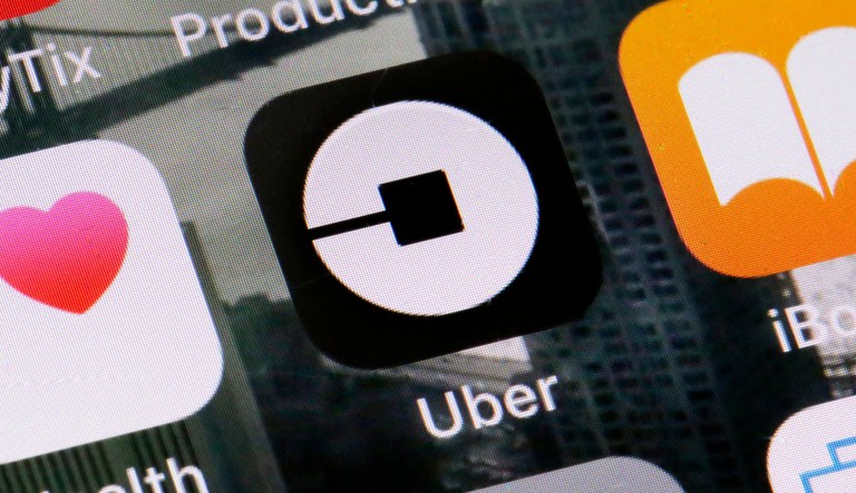 FILE - This Tuesday, June 12, 2018, file photo shows the Uber app on a phone in New York. On Monday, July 9, 2018, Uber said it is getting into the scooter-rental business, and is investing in Lime, a startup based in San Mateo, California.