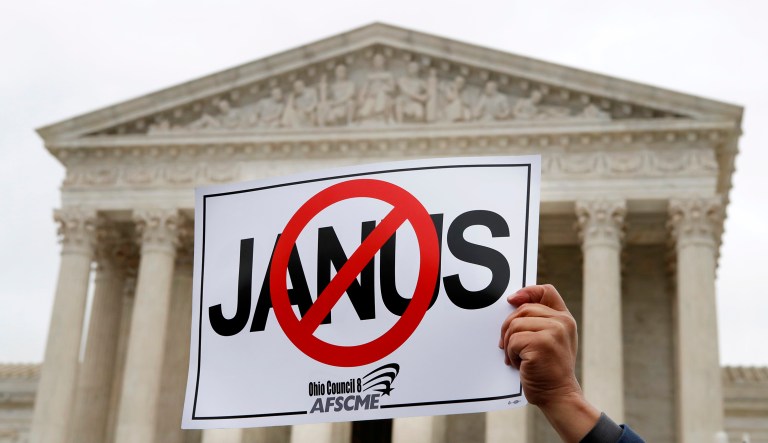 Stephen Roberts, with the American Federation of State, County and Municipal Employees (AFSCME), holds up a sign against Mark Janus during a rally outside of the Supreme Court, Monday, Feb. 26, 2018, in Washington. The Supreme Court takes up a challenge in a case that could deal a painful financial blow to organized labor. The court is considering a challenge to an Illinois law that allows unions representing government employees to collect fees from workers who choose not to join.