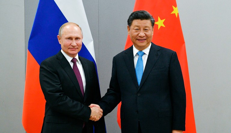 In this Nov. 12, 2019, file photo, Russian President Vladimir Putin, left, and China's President Xi Jinping shake hands prior to their talks on the sideline of the 11th edition of the BRICS Summit, in Brasilia, Brazil. 