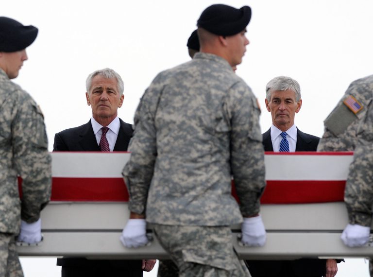 Defense Secretary Chuck Hagel, left, and Army Secretary John McHugh, right, watch an Army carry team move a transfer case containing the remains of Pfc. Cody J. Patterson Wednesday, Oct. 9, 2013 at Dover Air Force Base, Del. According to the Department of Defense, Patterson, 24, of Philomath, Ore., died Oct. 6, 2013 in Zhari district, Afghanistan of injuries sustained when enemy forces attacked his unit with an improvised explosive device. (AP Photo/Steve Ruark)