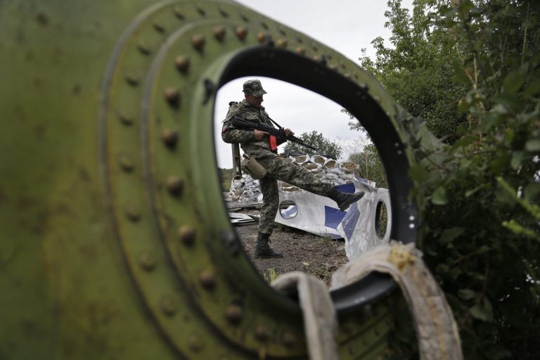 AP10ThingsToSee- A Pro-Russian rebel looks at pieces of the Malaysia Airlines Flight 17 plane near village of Rozsypne, eastern Ukraine, Tuesday, Sept. 9, 2014. The Dutch team investigating the downing of Malaysia Airlines Flight 17 over Eastern Ukraine says the crash was likely caused by the plane being hit by multiple 