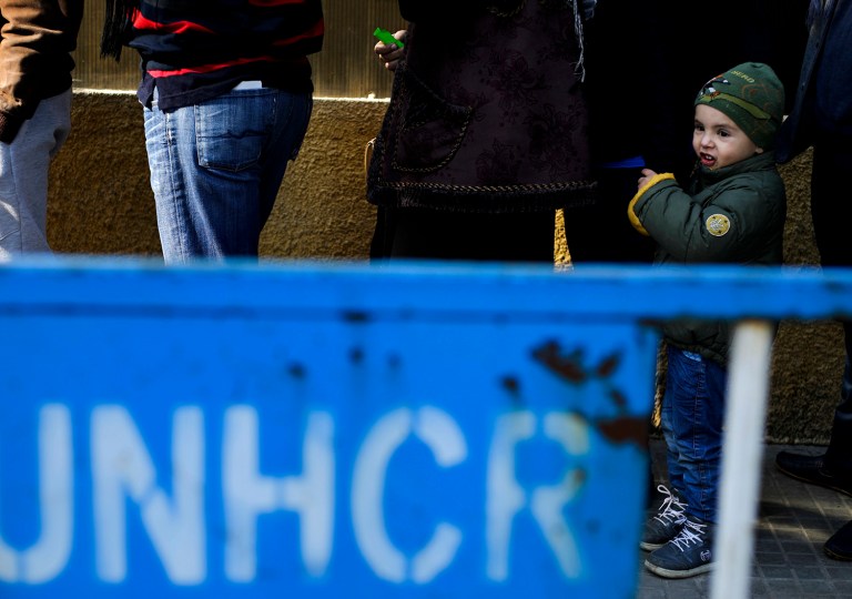 A Syrian boy waits in a queue with his mother as hundred of Syrian families wait to register at the United Nations High Commissioner for Refugees headquarters in Beirut, Lebanon, Monday, Jan. 30, 2017. (AP Photo/Hassan Ammar)