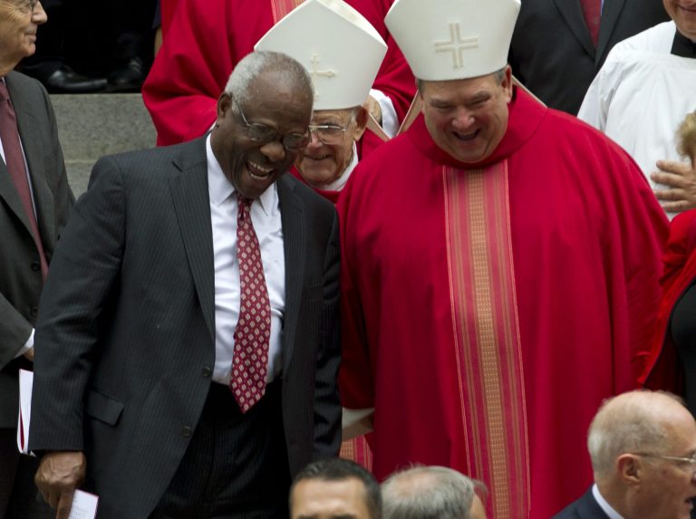 U.S. Supreme Court Justice Clarence Thomas speaks with a member of the clergy as they leave St. Mathews Cathedral after the Red Mass in Washington on Sunday, Oct. 2, 2016. (AP Photo/Jose Luis Magana)