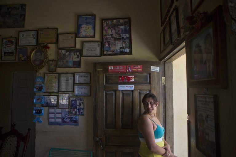 In this Saturday, July 19, 2014 photo, Elsa Ramirez, 27, deported a day earlier from the United States, stands just inside the doorway of her mother's home, in Tocoa, Honduras. Ramirez had heard that mothers traveling to the U.S. with children would be allowed to stay if they made it across the border, so she took off for the north with her 8-year-old daughter, Sandra, and 5-year-old son, Cesar, named for his dead father. (AP Photo/Esteban Felix)
