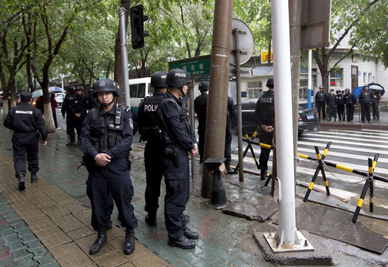 Armed policemen stand guard near the site of an explosion in Urumqi, northwest China's Xinjiang region, Thursday, May 22, 2014. Assailants in two SUVs plowed through shoppers while setting off explosives on a busy street market in China's volatile northwestern region of Xinjiang on Thursday, the local officials said, killing over two dozen people and injuring more than 90. The attack in the city of Urumqi was the bloodiest in a series of violent incidents that Chinese authorities have blamed on radical separatists from the country's Muslim Uighur minority.   (AP Photo/Andy Wong)