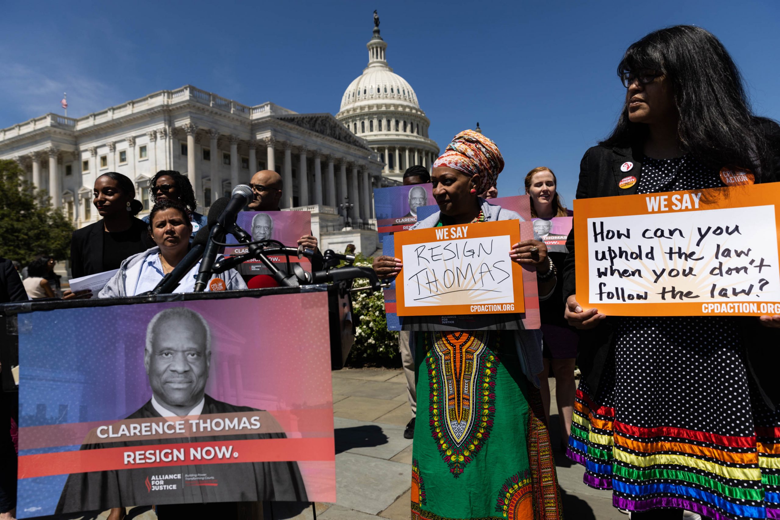Activists hold signs during a news conference outside the U.S. Capitol calling for the resignation of U.S. Supreme Court Associate Justice Clarence Thomas, on April 19, 2023, in Washington, DC. The nonprofit news outlet ProPublica reported that Thomas had been taking expensive vacations financed by billionaire Harlan Crow, who had also bought an undisclosed property from Thomas.