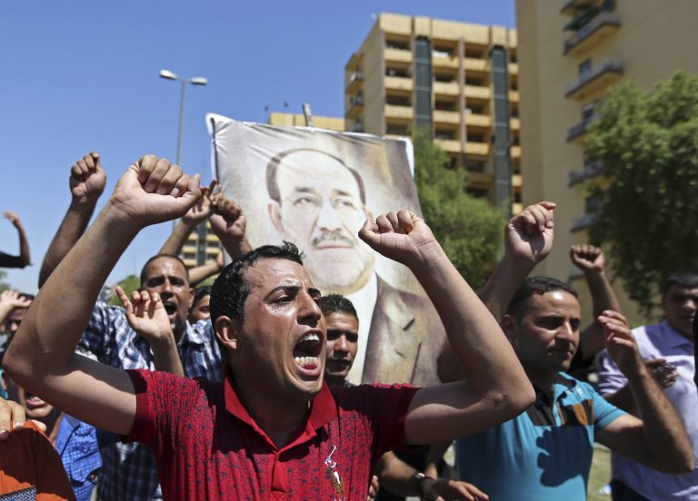 Iraqis chant pro-government slogans and display placards bearing a picture of embattled Prime Minister Nouri al-Maliki during a demonstration in Baghdad, Iraq, Monday, Aug. 11, 2014. Al-Maliki is taking his struggle to keep his job to the courts after announcing he will file a legal complaint on Monday against the country's newly elected president. President Barack Obama warned Americans on Saturday that the new campaign to bring security in Iraq requires military and political changes and 