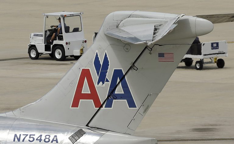 In this May 15, 2014 photo, a ramp worker rolls past an American Airlines McDonnell Douglas MD-82  at the Tampa International Airport in Tampa , Fla. American Airlines reports quarterly financial results on Thursday, July 24, 2014.