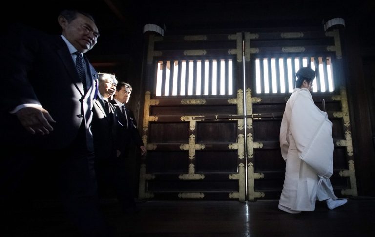 A group of Japanese lawmakers follow a Shinto priest to pay respect for the war dead at Yasukuni Shrine during an annual autumn festival in Tokyo, Friday, Oct. 17, 2014. (AP Photo/Eugene Hoshiko).