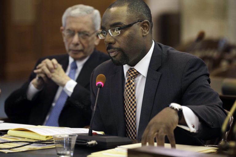 Deputy Commissioner Charles Richman, left, listens as  Richard E. Constable, III,  Commissioner New Jersey Department of Community Affairs answers a question about the current status of Superstorm Sandy relief funds during a Senate Budget Committee hearing Tuesday, April 29, 2014, at the Statehouse inTrenton, N.J. Senate Budget Committee chairman Sen. Paul A. Sarlo, D-Wood-Ridge, N.J., says New Jersey is facing significant late-year budget cuts because Gov. Chris Christie's administration overestimated how much tax revenue the state would receive. Sarlo says up to $800 million in fixes will be needed in the next two months to close out the fiscal year with a balanced budget, which the state constitution requires. (AP Photo/Mel Evans)