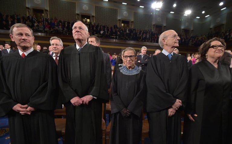 Justices (left to right) John G. Roberts, Anthony M. Kennedy, Ruth Bader Ginsburg, Stephen G. Breyer and Sonia Sotomayor stand before the State of the Union address by President Barack Obama on January 20, 2015.