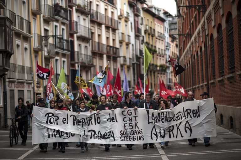 Workers march on the street holding a banner which reads:  ''For the distribution the work and wealth'', during May Day, in Pamplona northern Spain, Thursday, May 1, 2014. Tens of thousands of workers marked May Day in European cities with a mix of anger and gloom over austerity measures imposed by leaders trying to contain the eurozone's intractable debt crisis.(AP Photo/Alvaro Barrientos)