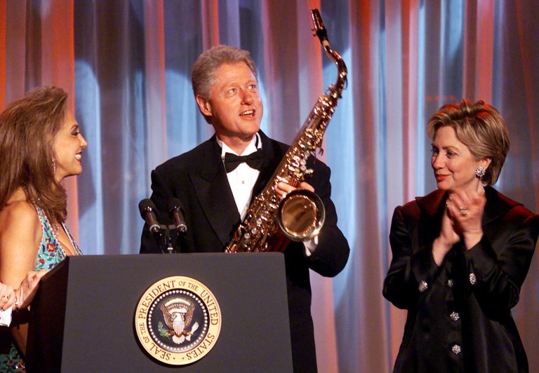 President Clinton accepts a saxophone from Denise Rich as Senator-elect Hillary Rodham Clinton D-N.Y. applauds at the Angel Ball 2000 dinner at the New York Marriott Marquis Hotel in New York, Thursday, Nov. 30, 2000. He later pardoned Rich's ex-husband in a scandal finale known as 