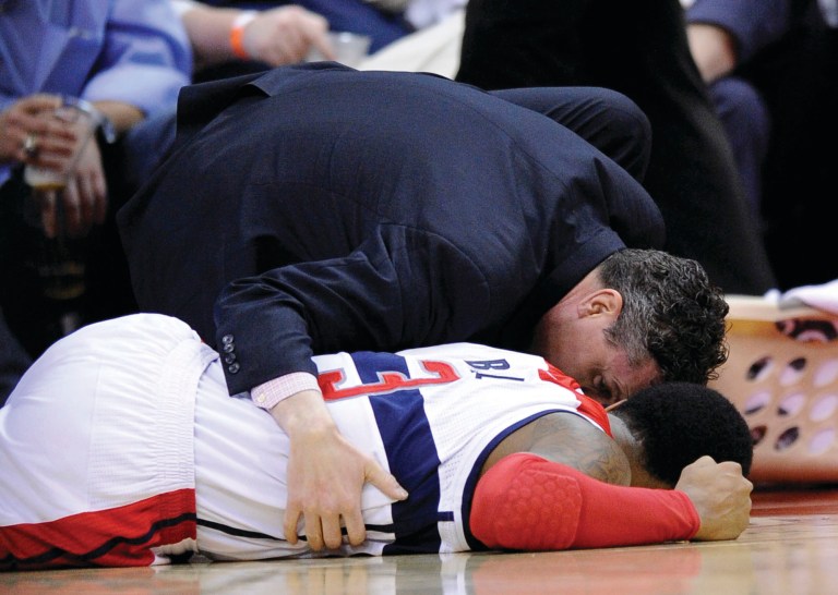 Nick Wass/AP
Bradley Beal was carried off after spraining his ankle, but John Wall scored the game's final six points in his absence to give the Wizards a win over the 76ers.