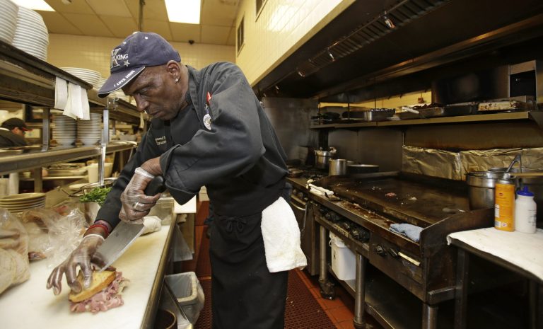 In this Friday, June 6, 2014 photo, executive chef Raymond Nicholson cuts a corned beef reuben sandwich at Corky & Lenny's Restaurant & Deli in Woodmere Village, Ohio. The Commerce Department releases first-quarter gross domestic product on Wednesday, June 25, 2014. (AP Photo/Tony Dejak)
