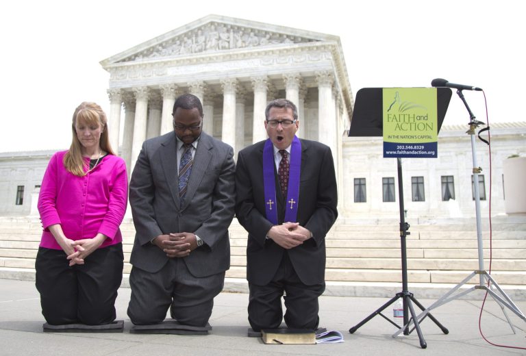 Rev. Dr. Rob Schenck, of Faith and Action, right, prays in front of the Supreme Court with Raymond Moore, center and Patty Bills, both also of Faith and Action, during a news conference, Monday, in Washington, after speaking in favor of the ruling by the court's conservative majority that was a victory for the town of Greece, N.Y., outside of Rochester. A narrowly divided Supreme Court upheld decidedly Christian prayers at the start of local council meetings on Monday, declaring them in line with long national traditions though the country has grown more religiously diverse. (AP Photo/Carolyn Kaster)