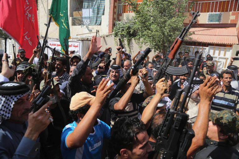 Iraqi Shiite tribal fighters raise their weapons and chant slogans against the al-Qaida inspired Islamic State of Iraq and the Levant (ISIL) in Baghdad's Sadr city, Iraq, Saturday, June 14, 2014. Thousands of Shiites from Baghdad and across southern Iraq answered an urgent call to arms Saturday, joining security forces to fight the Islamic militants who have captured large swaths of territory north of the capital and now imperil a city with a much-revered religious shrine. (AP Photo/Karim Kadim)